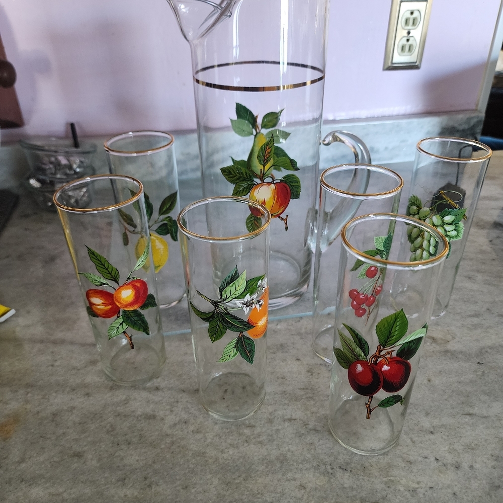 Fruit designed pitcher and 6 corresponding glasses.  Gold trimmed